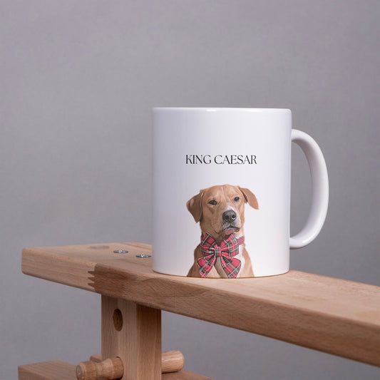 White mug with a dog illustration and 'KING CAESAR' text on a wooden surface with gray background